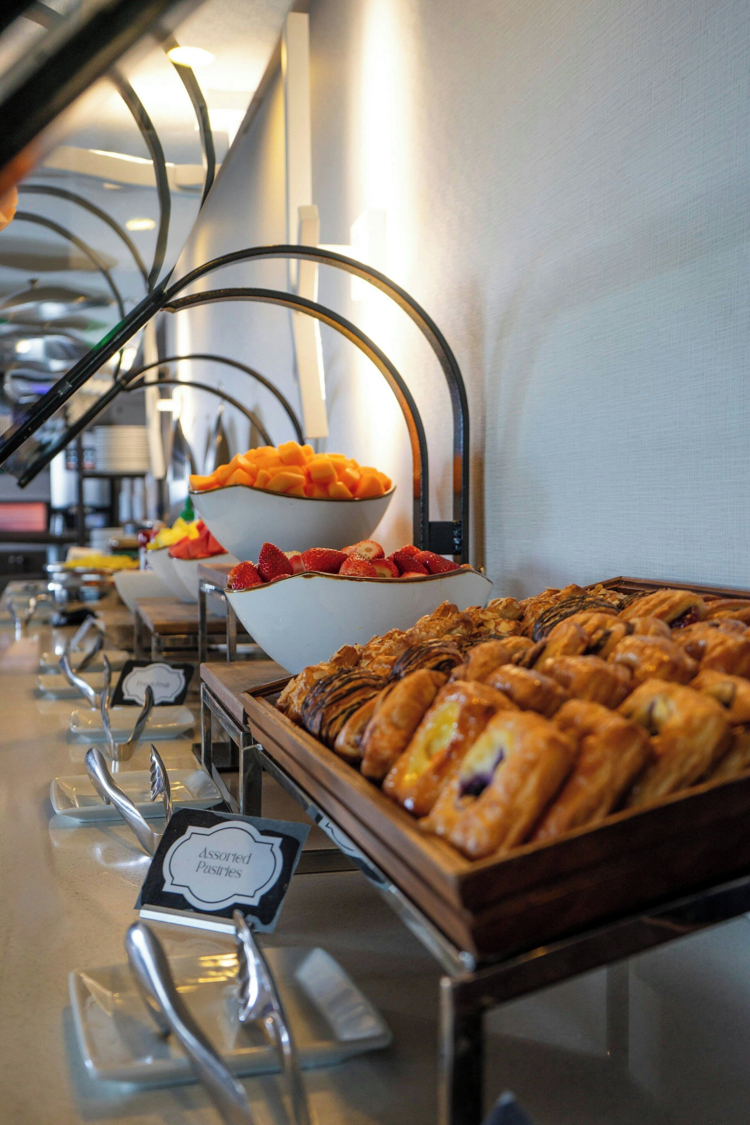 Ein Buffet mit verschiedenen Speisen, darunter Backwaren und Obst.