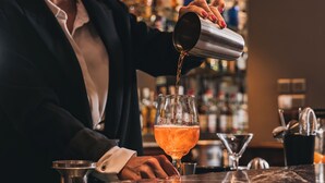 A bartender pouring a drink into a glass. - Hôtel Régent Contades  By Stay Collection (Strasbourg)