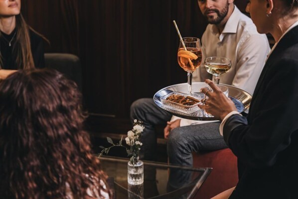 A group of people seated around a table with drinks and a dessert plate.