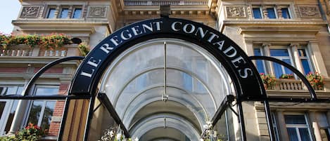 A grand entrance with the inscription "LE REGENT CONTADES" above a glass archway.