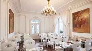 A formal dining room with white chairs, tables, and a chandelier. - Hôtel Régent Contades  By Stay Collection (Strasbourg)