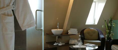 A modern bathroom with a large mirror, a sink, and a chair.