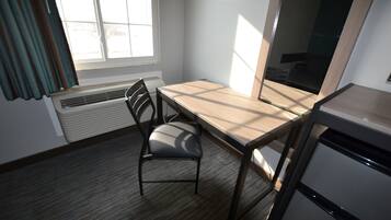 A small, well-lit room with a wooden desk, a chair, and a radiator.