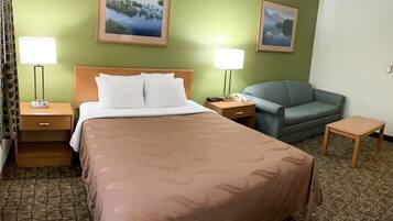 A hotel room with a bed, two nightstands, a desk, a chair, and two wall-mounted lamps.