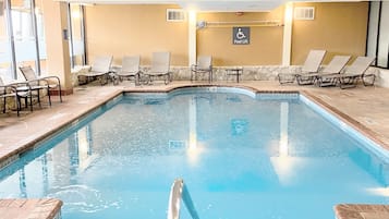 Una piscina techada, sillones reclinables de piscina