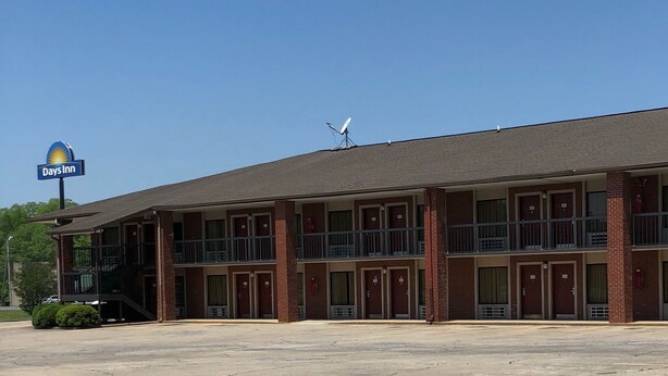 A Days Inn with a two-story building, multiple rooms, and a parking lot. - Days Inn by Wyndham Childersburg/Sylacauga (Childersburg)