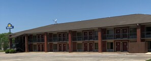 A Days Inn with a two-story building, multiple rooms, and a parking lot. - Days Inn by Wyndham Childersburg/Sylacauga (Childersburg)