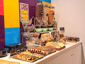 Buffet com diversas opções de comida, incluindo cereais, sementes e produtos de panificação.