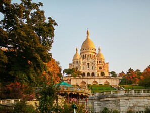 A large, ornate building with multiple domes and a central dome, surrounded by trees and a small carousel. - ibis Styles Paris Tolbiac Bibliotheque (Paris)