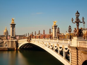 A bridge with ornate statues and lamp posts, a calm river below, and a dome structure in the background. - ibis Styles Paris Tolbiac Bibliotheque (Paris)
