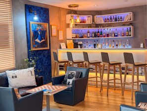 A bar area with shelves of liquor bottles, a framed picture, and bar stools. - ibis Styles Paris Tolbiac Bibliotheque (Paris)