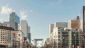 A cityscape with modern buildings, a water feature, and a prominent arch structure.
