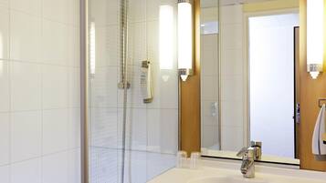 A modern bathroom with a shower, a sink, and a mirror.
