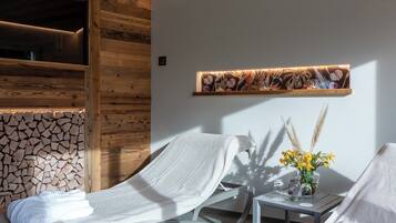 Relax in a serene spa area with a comfortable chair, a vase of flowers, and a peaceful ambiance.