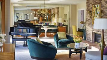 A spacious living room with a grand piano, comfortable seating, a glass coffee table, and a fireplace.