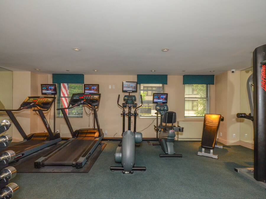 A gym with treadmills, elliptical machines, and weight equipment.