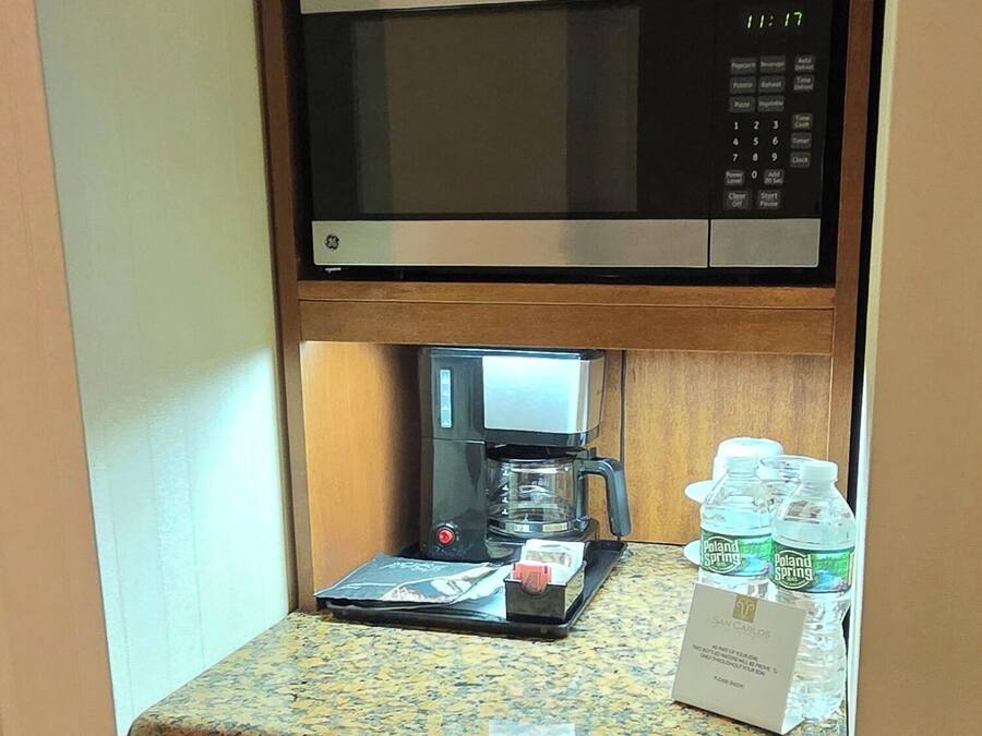 Una cuina compacta amb microones, cafetera i rentaplats.