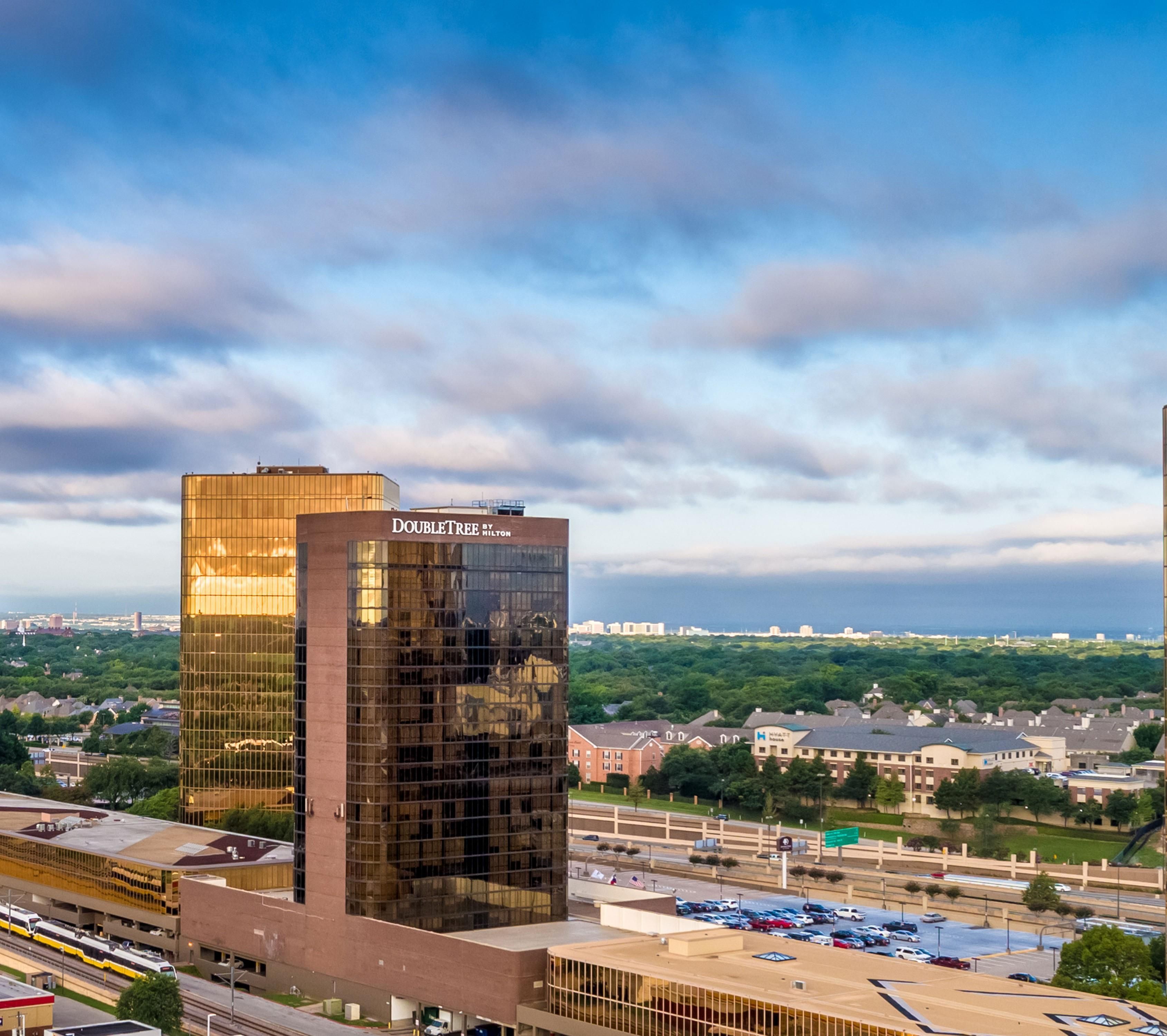 Un edificio moderno con fachada de vidrio y un letrero que dice 'DOUBLETREE BY HILTON'.