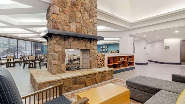 A spacious lobby with a stone fireplace, comfortable seating, and a view through large windows. - Country Inn & Suites by Radisson, Atlanta Galleria/Ballpark, GA (Atlanta)