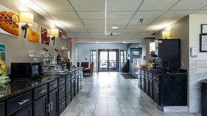Una cocina moderna equipada con microondas, cafetera y un refrigerador grande.