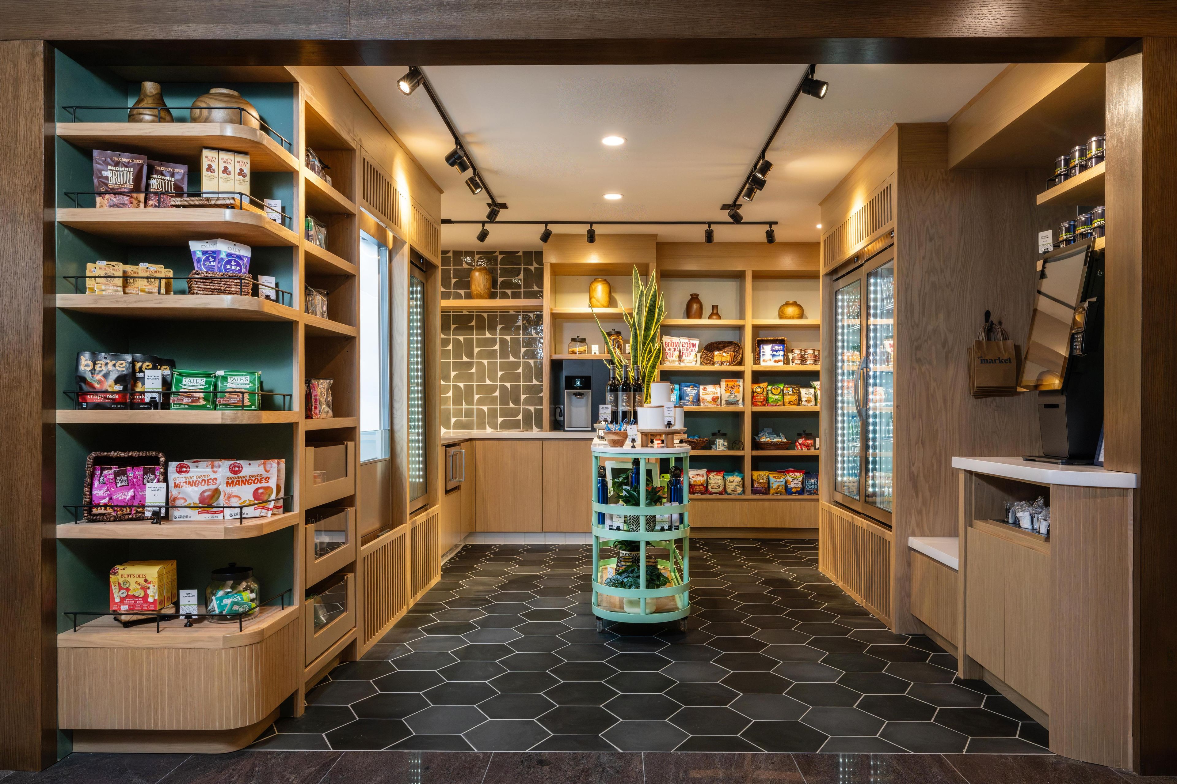 Un espace de vente moderne et bien éclairé, doté d’étagères en bois où sont présentés divers produits.