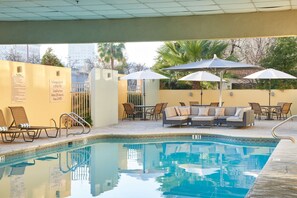 A pool area with lounge chairs, umbrellas, and a pool. - DoubleTree by Hilton Fresno Convention Center (Fresno)