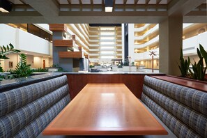 A spacious atrium with a central seating area, multiple levels of balconies, and indoor plants. - DoubleTree by Hilton Fresno Convention Center (Fresno)
