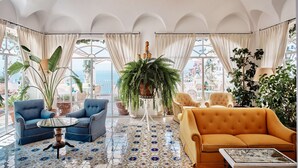 A spacious room with a large window, a chandelier, and a 'DON'T WOBBY' sign. - Le Sirenuse (Positano)