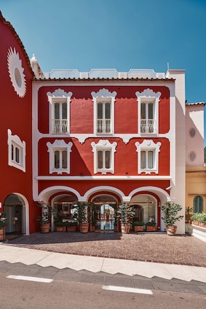 A red building with white trim, multiple windows, and balconies.