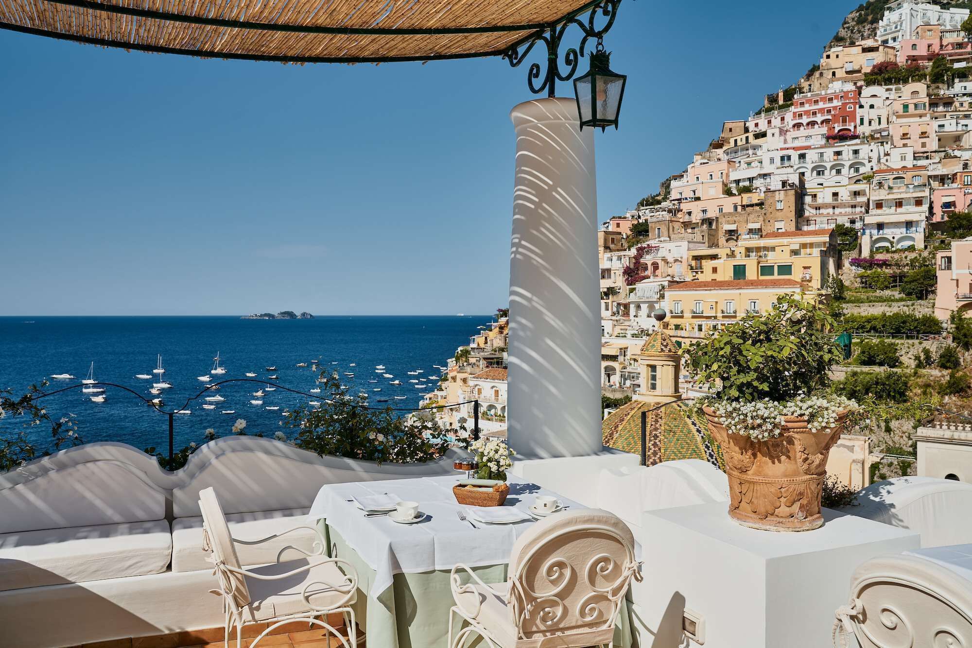 Una terraza con vistas al mar y una ladera llena de edificios coloridos.