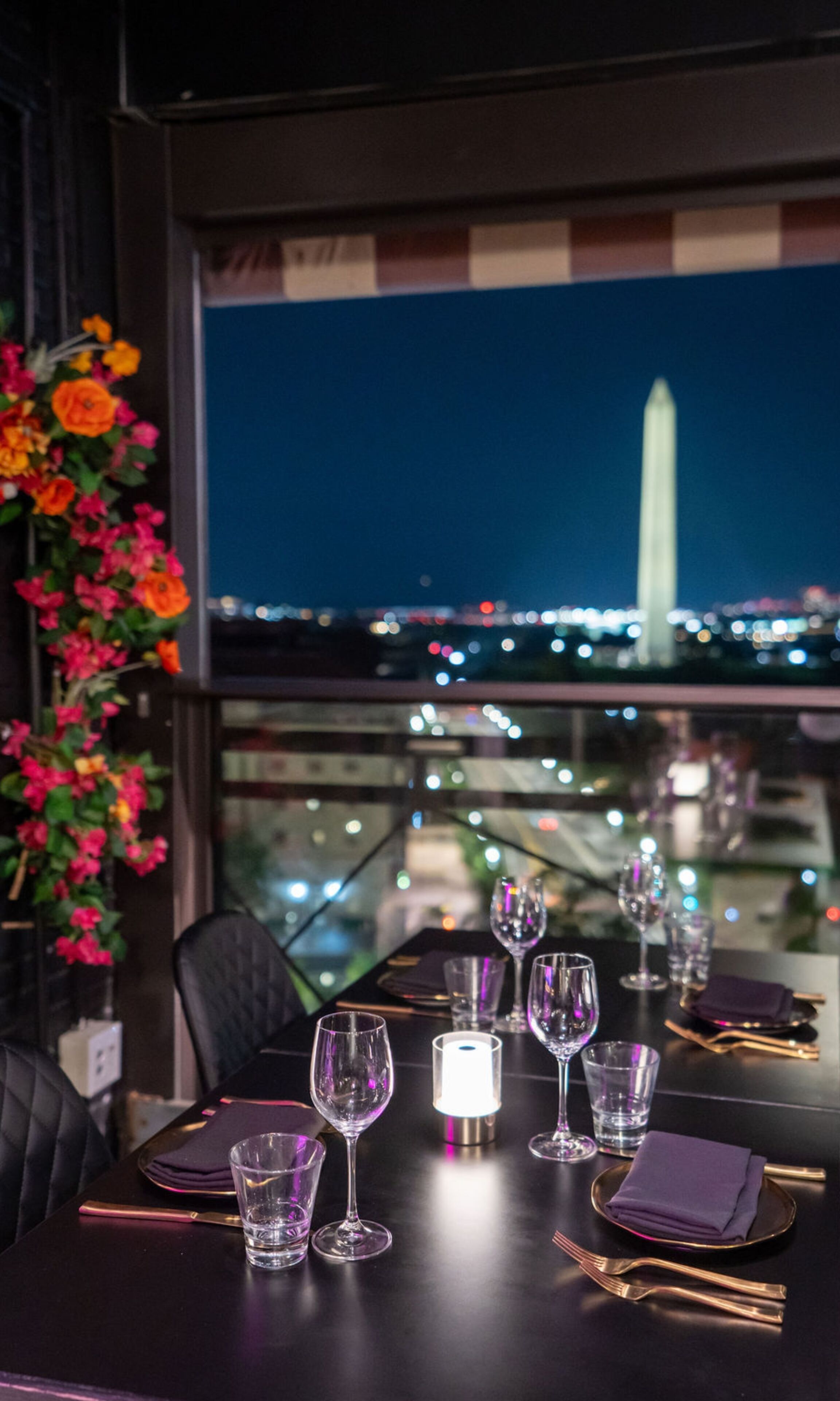 A table set for dining with a city view, including a prominent monument.