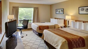 Une chambre d’hôtel avec deux lits, un bureau avec une télévision et une fenêtre avec des rideaux.
