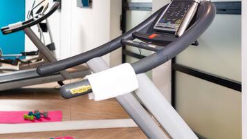 A gym with exercise equipment, including a treadmill and dumbbells.