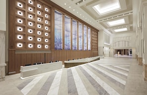 Een ruime hotellobby met een lange receptiebalie, houten lambrisering en een groot raam met uitzicht.