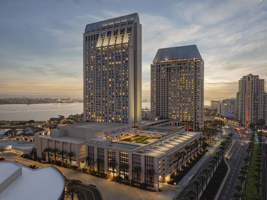 A high-rise building complex with multiple floors, large windows, and a waterfront view.
