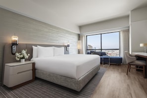 Une chambre d’hôtel moderne avec un grand lit, un bureau et une vue sur la ville.