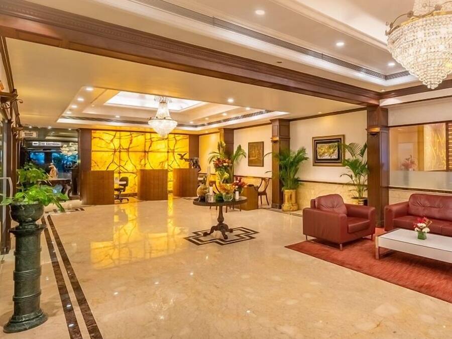 A spacious lobby with a marble floor, a chandelier, and seating areas.