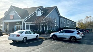 A two-story building with a porch and a sign that reads "EconoLodge." - Econo Lodge & Suites Grand Rapids Airport (Grand Rapids)