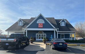 A two-story building with a blue exterior and a white roof. There is a sign that reads "EconoLodge" above the entrance. - Econo Lodge & Suites Grand Rapids Airport (Grand Rapids)