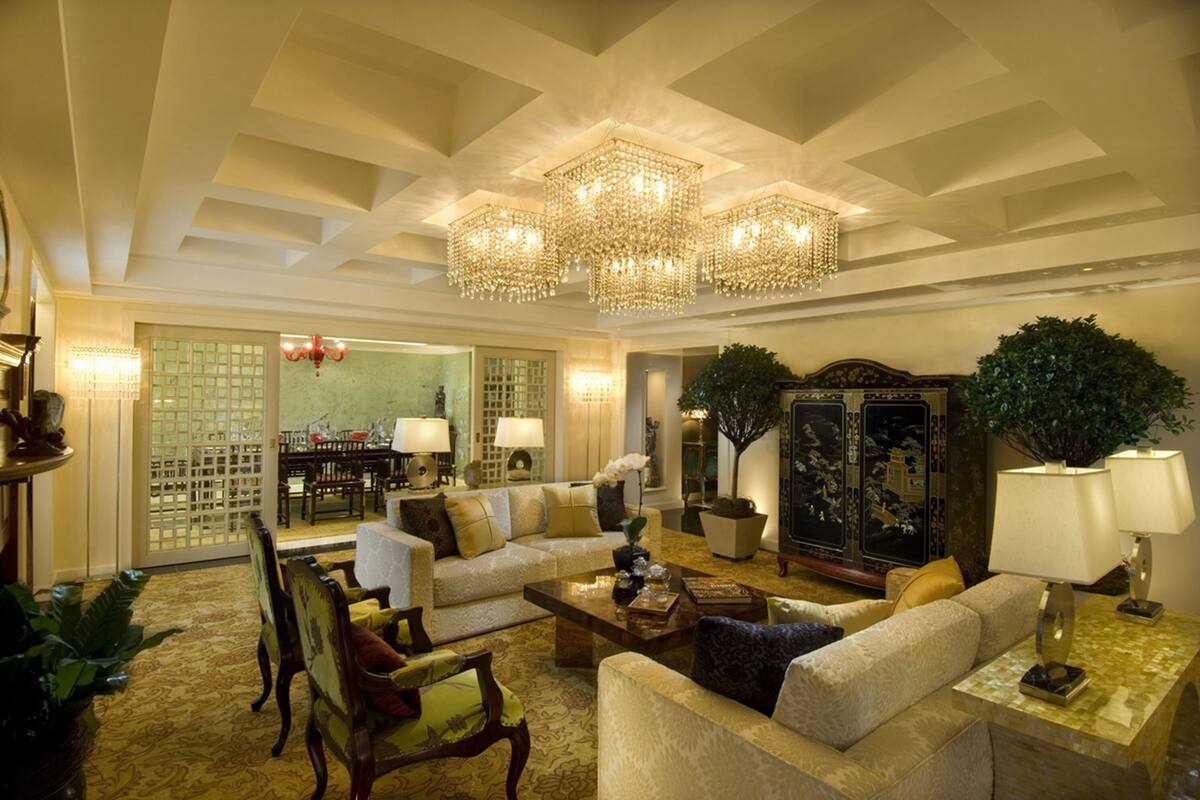 Un salón amplio con techo alto, candelabros ornamentados y muebles tradicionales.