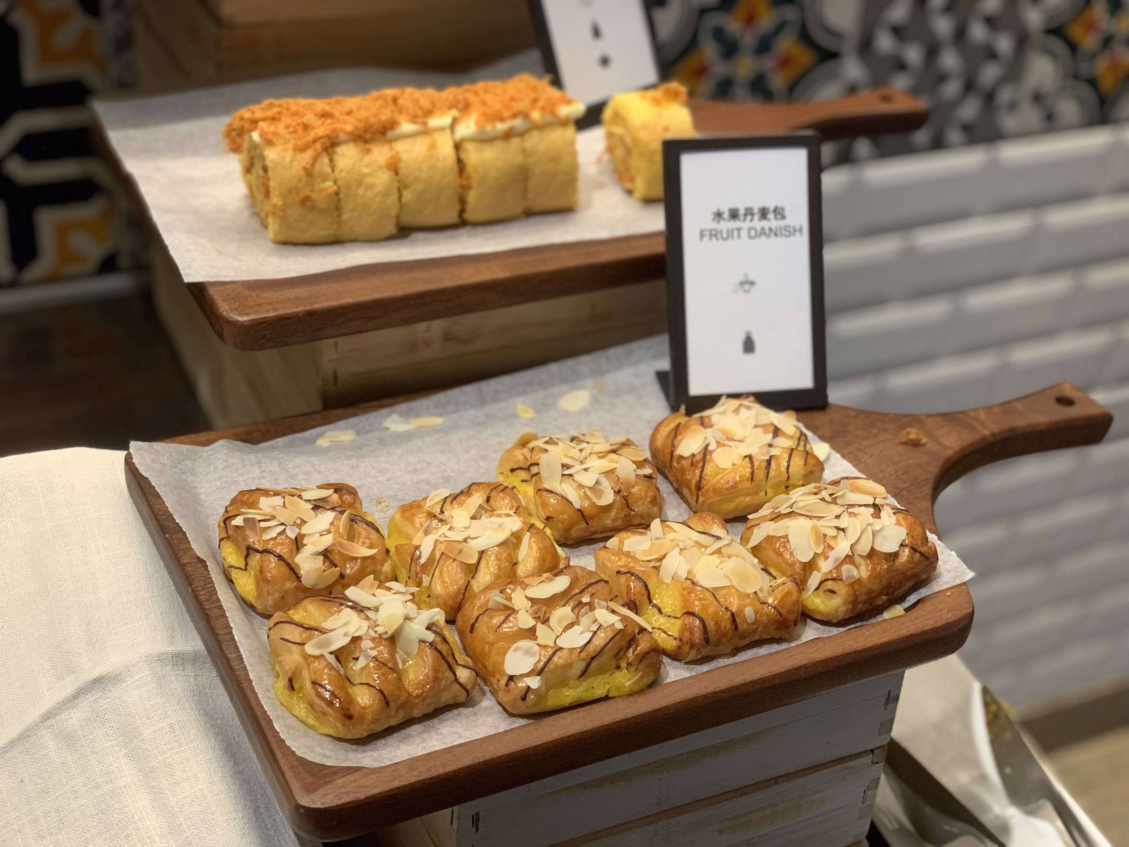 A display of pastries with a sign indicating 'FRUIT DANISH'.