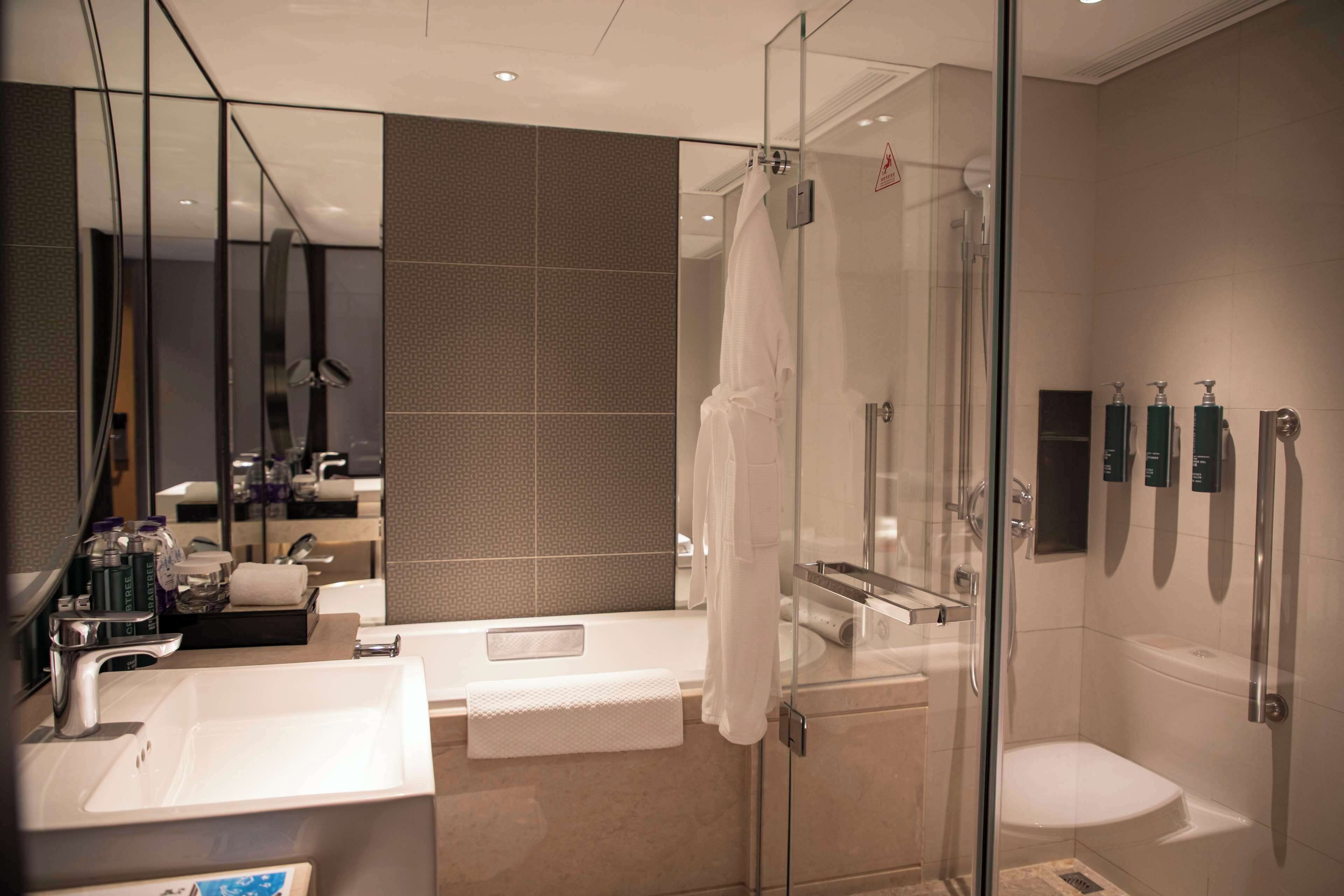A modern bathroom with a glass shower enclosure, a white sink, and a bathtub.