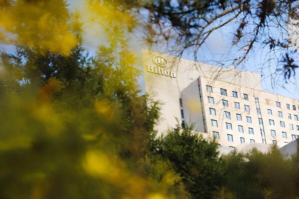 Un bâtiment arborant le logo Hilton, ce qui indique qu’il s’agit d’un hôtel Hilton.