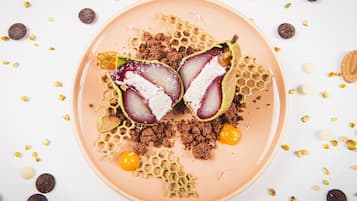 A dessert plate with a honeycomb design, a halved fruit, and scattered nuts.