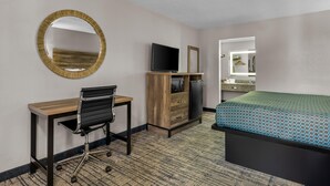 A hotel room with a desk, chair, television, wardrobe, and a bed. - Americas Best Value Inn Douglasville (Douglasville)
