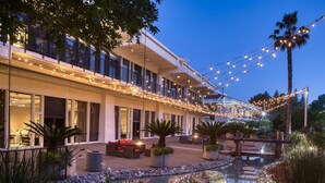 A hotel with a covered outdoor area, a pool, and string lights. - DoubleTree by Hilton Sacramento (Sacramento)