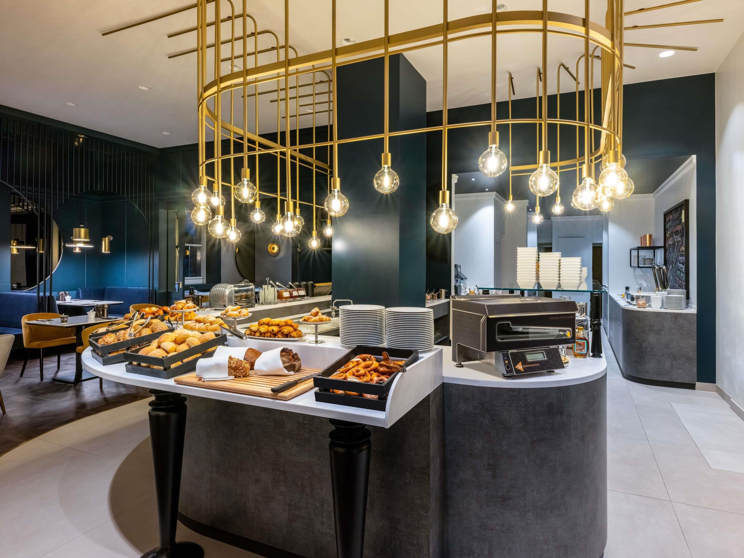 A modern breakfast bar with a variety of pastries and a coffee machine.