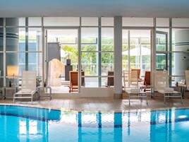 Una piscina techada, sillones reclinables de piscina