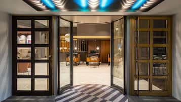 Eine moderne Lobby mit Schachbrettmuster-Teppich, einer Rezeption und einer Sitzecke.