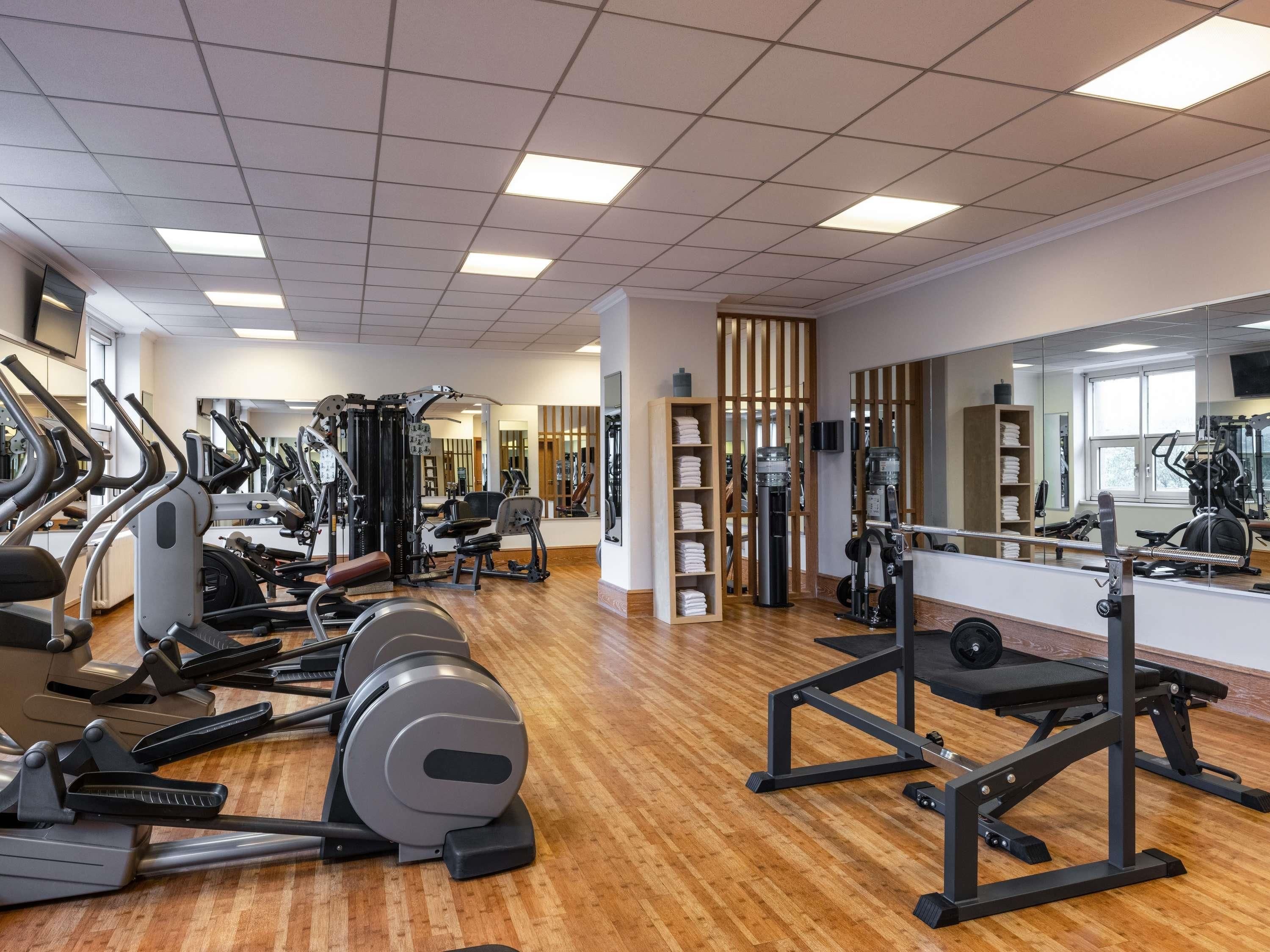 A gym with cardio machines, weightlifting equipment, and mirrors.